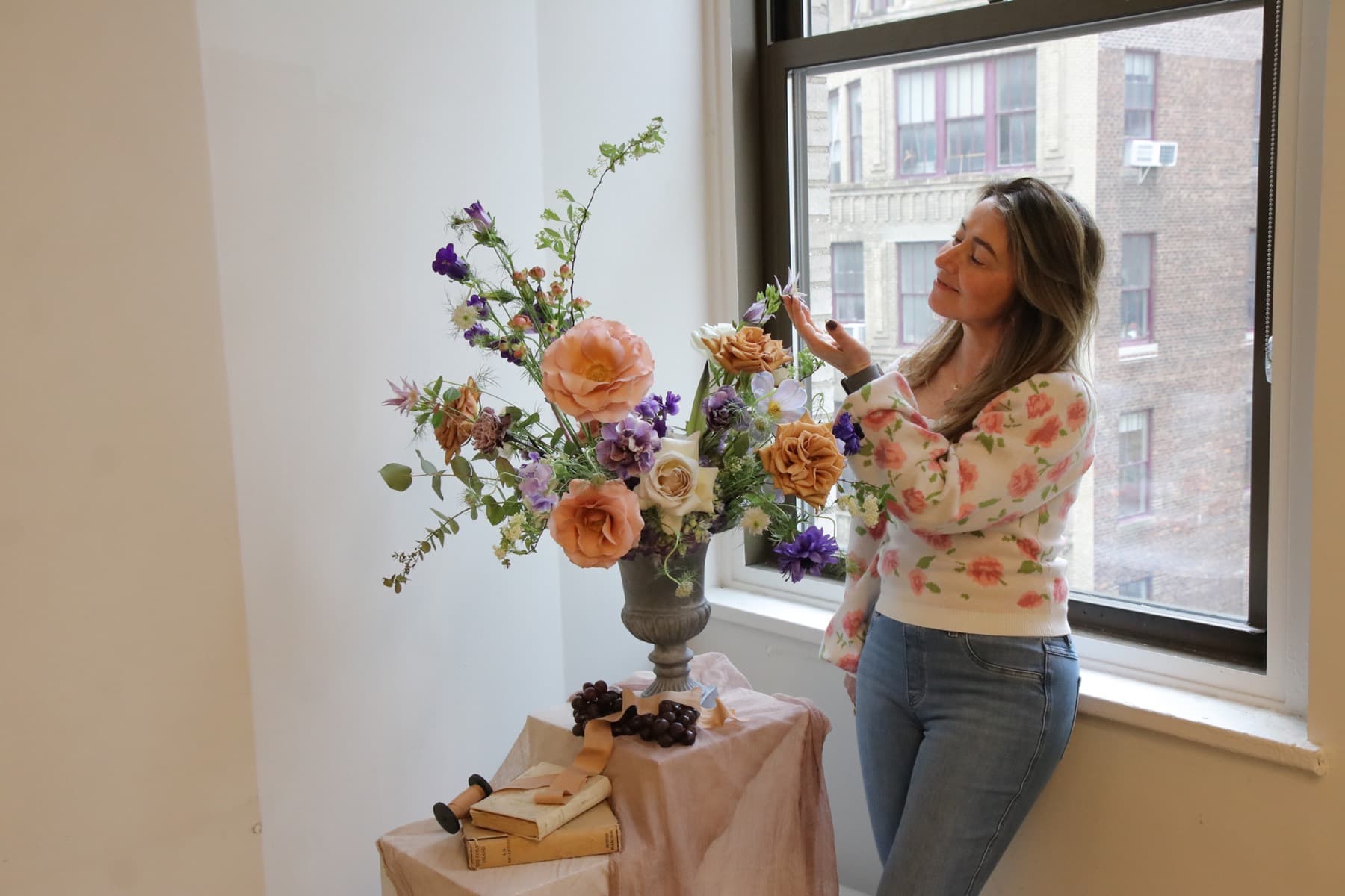 A florist arranging a bouquet in a sunlit New England flower shop.